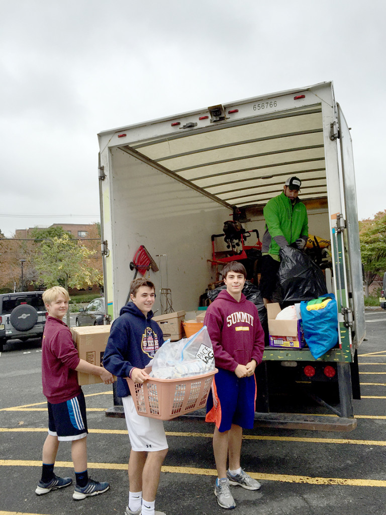 (above l-r) Chris Waltzinger, Reilly Newsham and Justin Cise loading items to be donated to the Purple Heart Foundation.