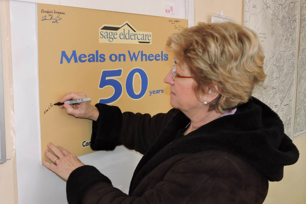 (above) Summit Mayor Nora G. Radest signed the 50th Anniversary Meals on Wheels card of volunteers at SAGE Eldercare on Thursday, January 7 and then delivered meals to local residents with Carol Graham, a SAGE board member and Summit resident.