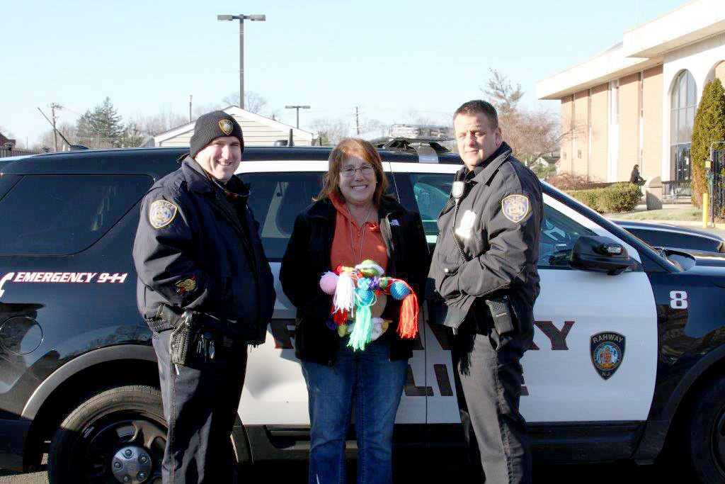 (above l-r) Rahway Police Officer Robert Zarzycki, Sharon Young and Police Officer TJ Salvia accepting the “Blanket Babies” for use in Rahway Police vehicles.