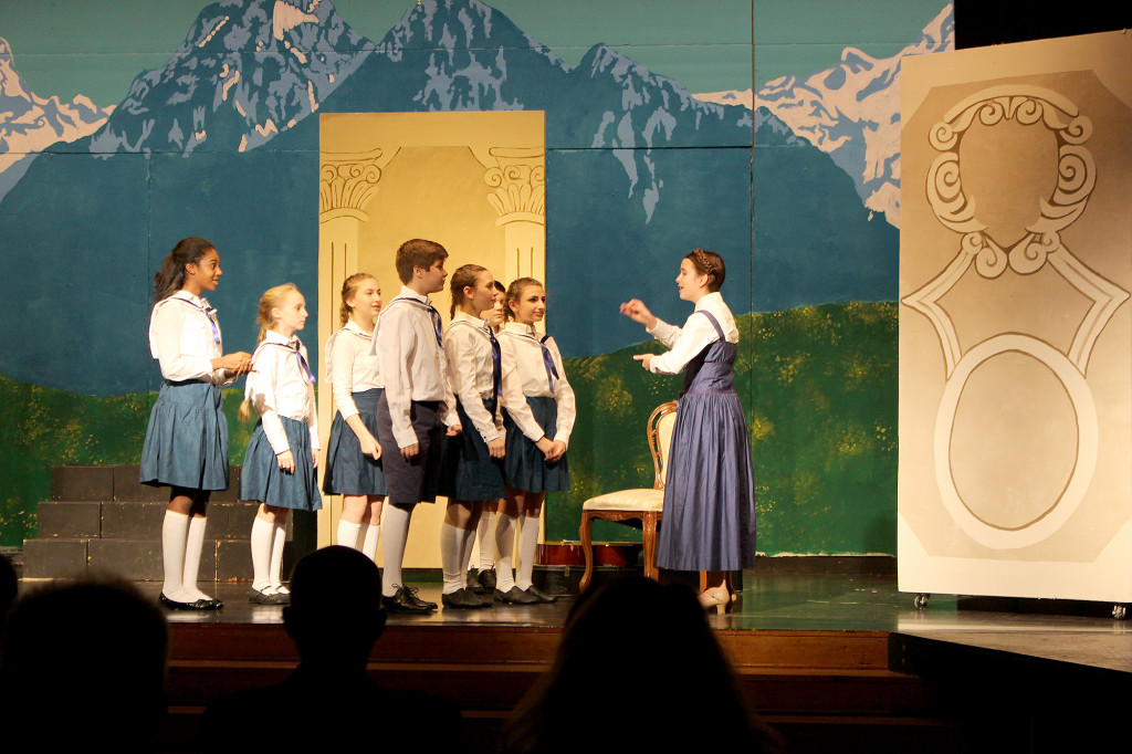 (above) Warren Middle School 7th Grader Melissa Miketen (Maria) leads her Von Trapp Family charges in song at the Feb. 22 Board of Education meeting. L-R: Ariya Blow (Liesl), Paulina Przybylski (Gretl), Ally Devico (Louisa), Christopher Gagliano (Friedrich), Julia Neuwirth (Brigitta), James Young (Kurt), Marianna Renda (Marta), Melissa Miketen (Maria). Photo Credit: Mary Ann McGann.