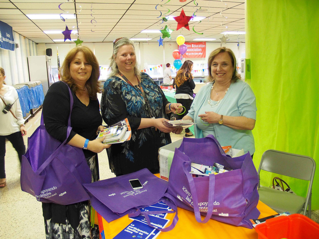 (above) NJEA Priority School Consultant, Julia Mahoney, speaks with Dawn Beviano and Theresa Villani members of Linden Board of Education and parents regarding reading strategies and they received a FAST tote filled with books of various genres for their children.