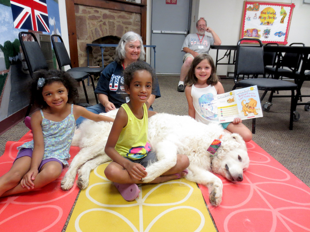 (above) During the Read To A Dog program children had an opportunity to practice their reading skills as they enjoyed a relaxing visit with Glow, the therapy dog.