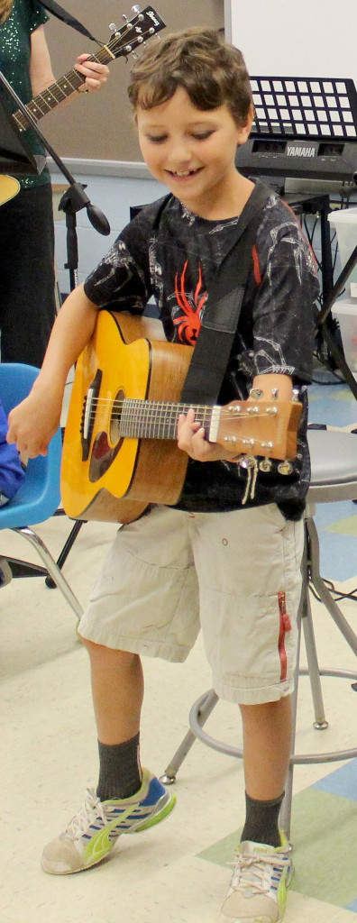 (above) Grade schoolers Brady O’Shea and Vito Cocuzza rock out in “School of Rock” with the help of Woodland music teacher Karen Sutherland.