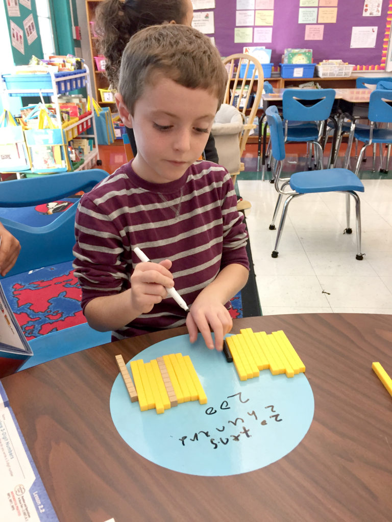 (above) Students use blocks to understand place value and to model, write, and compare 3-digit numbers in Mrs. Bakker’s 2nd grade class. Manipulatives, models, pictures, and symbols are used to build mathematical understanding as part of the Go Math! program. The program helps students engage with the Common Core State Standards.