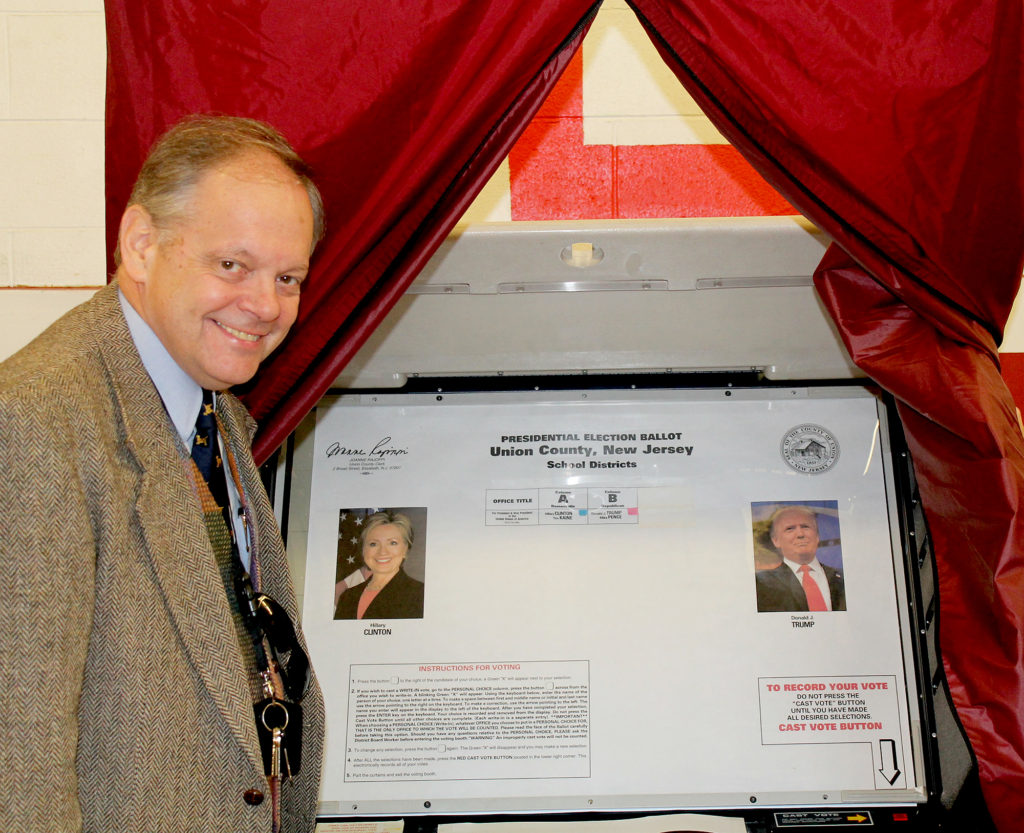 (above) Organizer John Odin demonstrates an actual voting booth brought in for the election.Photos by: Joseph Mudrak