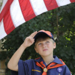 Tiger cub scout saluting the American flag